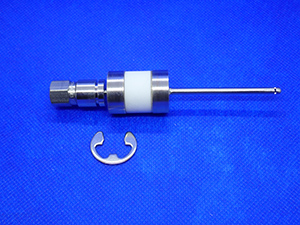 This is an image of a gas isolator with a connecting nut on one end and a 1-inch outlet tube on the other end. There is a clip included to secure it to a source.